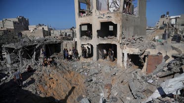 Palestinians look at buildings destroyed in the Israeli bombardment in the morgue in Deir al Balah, Gaza Strip, Tuesday, Nov. 7, 2023. (AP Photo/Hatem Moussa)