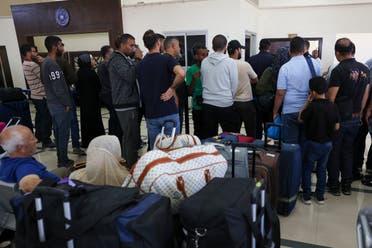 Palestinian dual nationals and foreigners wait to cross the Rafah border crossing with Egypt, in the southern Gaza Strip, on November 7, 2023, amid the ongoing battles between Irael and Hamas. (AFP)