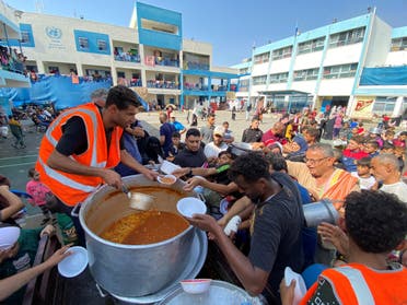 Palestinians, who fled their houses due to Israeli strikes, gather to get their share of charity food offered by volunteers, amid food shortages, at a UN-run school where they take refuge, in Rafah, in the southern Gaza Strip, October 23, 2023. (Reuters)