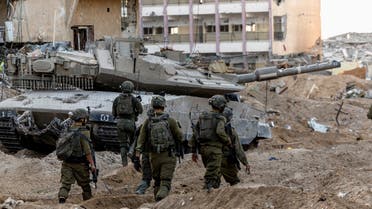 Israeli soldiers walk through rubble, amid the ongoing ground invasion against Palestinian Islamist group Hamas in the northern Gaza Strip, November 8, 2023. (Reuters)