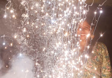 A woman watches as firecrackers burn during Diwali, the Hindu festival of lights, in Mumbai, India, on November 12, 2023. (Reuters)