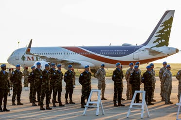Peacekeepers of the United Nations Interim Force in Lebanon (UNIFIL) stand near a Middle East Airlines (MEA) Airbus A321 aircraft during the repatriation ceremony for Irish soldier Sean Rooney who was killed on a UN patrol, at Beirut international airport on December 18, 2022. (AFP)