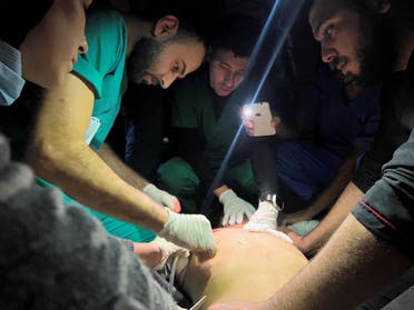Medical services use phone flashlights to assist a Palestinian wounded in Israeli strikes at the Indonesian hospital after Al-Shifa hospital has gone out of service amid Israeli ground offensive, in the northern Gaza Strip, November 16, 2023. (Reuters)
