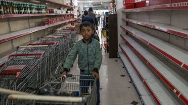 A Palestinian boy stands near empty shelves at a supermarket in Rafah, in the southern Gaza Strip on November 13, 2023, amid the ongoing battles between Israel and the Palestinian militant group Hamas. (File photo: AFP)