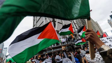 Demonstrators in support of Palestinians wave Palestinian flags during a protest in Toronto, Ontario, Canada, on October 9, 2023. Israel imposed a total siege on the Gaza Strip Monday and cut off the water supply as it kept bombing targets in the crowded Palestinian enclave in response to the Hamas surprise assault it has likened to the 9/11 attacks. Reeling from the Islamist group's unprecedented ground, air and sea attacks, Israel has counted more than 700 dead and launched a withering barrage of strikes on Gaza that have raised the death toll there to 560 people. (Photo by Cole BURSTON / AFP)