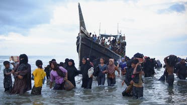 Rohingya Muslims walk through waters after they are temporarily allowed by locals to land in Ulee Madon beach, North Aceh, Indonesia, November 16, 2023. REUTERS/Stringer NO RESALES. NO ARCHIVES
