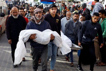 A man carries the body of a Palestinian child killed in Israeli strikes, amid the ongoing conflict between Israel and Palestinian group Hamas, in Khan Younis in the southern Gaza Strip, November 19, 2023. (Reuters)