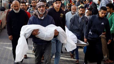 A man carries the body of a Palestinian child killed in Israeli strikes, amid the ongoing conflict between Israel and Palestinian group Hamas, in Khan Younis in the southern Gaza Strip, November 19, 2023. (Reuters)
