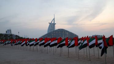 A flag garden in the colors of the United Arab Emirates is set up along the beach in front of the Burj Al-Arab building, to celebrate the annual UAE flag day in Dubai on November 3, 2023. (AFP)