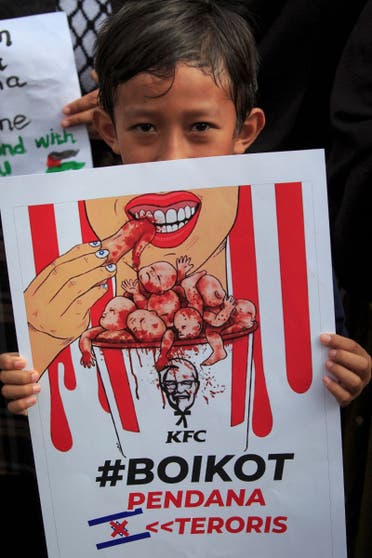 Un manifestante sostiene un cartel que pide boicotear los productos y empresas proisraelíes durante una protesta para mostrar su solidaridad con el pueblo palestino en Yogyakarta el 11 de noviembre de 2023. (AFP)