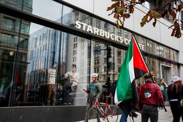 La gente observa desde el interior de un Starbucks mientras los manifestantes marchan en apoyo de los palestinos en Gaza, en medio del conflicto en curso entre Israel y Hamás, en Washington, EE.UU., el 4 de noviembre de 2023. (Reuters)
