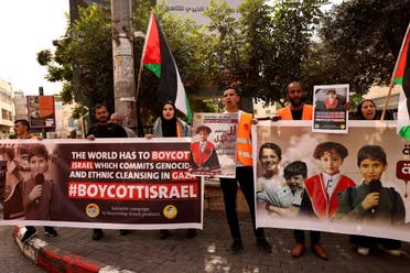 Los palestinos sostienen carteles pidiendo el boicot de los productos israelíes durante una manifestación en la ciudad ocupada de Hebrón, en Cisjordania, el 28 de octubre de 2023, en medio de las batallas en curso entre Israel y el grupo palestino Hamás.  (AFP)