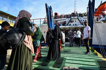 Rohingya refugees board a ferry at a beach in the Sabang island of Aceh province, Indonesia on November 22, 2023, as they are relocated by Indonesian authorities. (AFP)