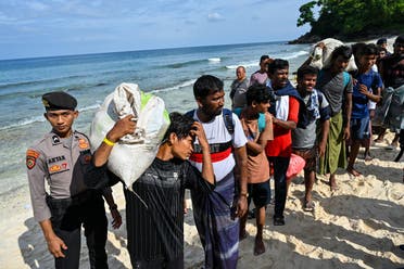 Rohingya refugees’ queue with their belongings at a beach in the Sabang island of Aceh province, Indonesia on November 22, 2023. (AFP)