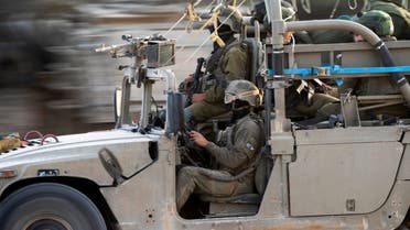 Israeli army soldiers drive into an army staging area near the Gaza Strip border Sunday Nov. 23, 2023. The cease-fire between Israel and Hamas appeared to be back on track Sunday after the release of a second group of militant-held hostages and Palestinians from Israeli prisons, and Egypt said it had received new lists for an expected third release.(AP Photo/Victor R. Caivano)
