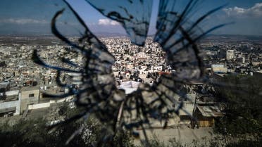 A picture taken through a bullet hole in a window shows a view of Jenin city in the Israeli-occupied West Bank, on November 18, 2023. (AFP)