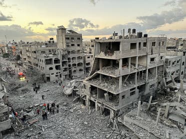 Palestinians walk at the site of Israeli strikes on houses, in Jabalia refugee camp in the northern Gaza Strip November, 21, 2023. (Reuters)