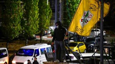 A man waves the yellow flag of Fatah group as he waits for the release of Palestinian prisoners in exchange for Israeli hostages held by Hamas, in Ramallah in the occupied West Bank on November 27, 2023. French, German and Argentinian dual nationals are among 11 Israeli hostages to be freed in a fourth group by Hamas in exchange for 33 Palestinians in Israeli prisons, Qatar said on November 27, 2023. (Photo by John MACDOUGALL / AFP)