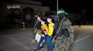 Los rehenes que fueron secuestrados por hombres armados de Hamás durante el ataque del 7 de octubre contra Israel son entregados por militantes de Hamás a miembros del CICR.  (Reuters)