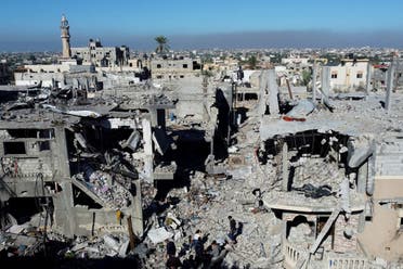 Palestinos caminan entre los escombros, mientras inspeccionan casas destruidas en los ataques israelíes durante el conflicto, en medio de una tregua temporal entre Israel y Hamás, en el campo de refugiados de Khan Younis, en el sur de la Franja de Gaza, el 29 de noviembre de 2023. (Reuters)