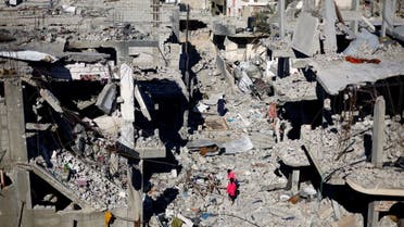 Palestinian children walk among the houses destroyed in Israeli strikes during the conflict, amid the temporary truce between Israel and the Palestinian militia group Hamas, at Khan Younis refugee camp, in the southern Gaza Strip, November 29, 2023. (Reuters)