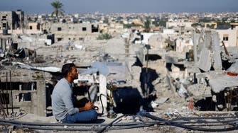 فلسطيني يدخن الشيشة فوق ركام منزله في غزة.. 