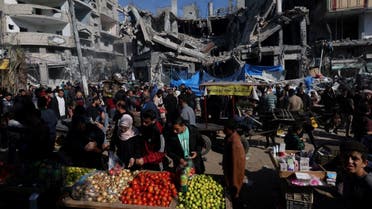Palestinians shop in an open-air market near the ruins of houses and buildings destroyed in Israeli strikes during the conflict, amid a temporary truce between Hamas and Israel, in Nuseirat refugee camp in the central Gaza Strip November 30, 2023. (Reuters)