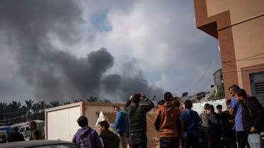 Palestinians look at smoke following an Israeli airstrike in Khan Younis, Gaza Strip, Friday, Dec. 1, 2023. (AP Photo/Fatima Shbair)