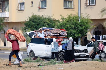 Residents of the Qatari-funded Hamad Town residential complex in Khan Younis in the southern Gaza Strip, carry some of their belongings as they flee their homes after receiving notification from the Israeli army of an imminent strike, on December 2, 2023. (AFP)