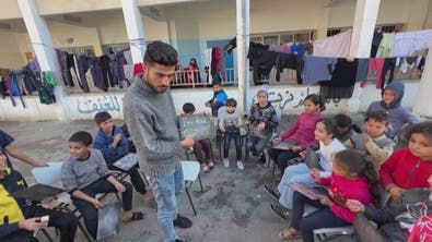 معلم فلسطيني يدرس الأطفال النازحين في مدرسة تأوي الفارين من القصف