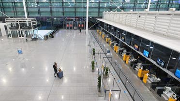 A passenger stands in Terminal 2 of an otherwise deserted Franz-Josef-Strauss airport in Munich, Germany, on November 12, 2020. (Reuters)