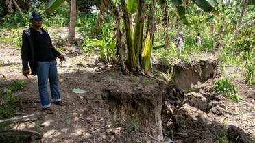 Residents stand near a huge crack in the land caused by a 6.4 magnitude earthquake the night before, in the town of Magsaysay in Davao del Sur on the southern Philippine island of Mindanao on October 17, 2019. (AFP)