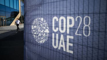 A man walks past a COP28 sign at the venue of the United Nations climate summit in Dubai on November 30, 2023. (AFP)