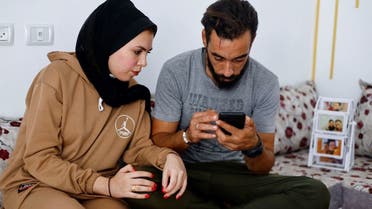 Palestinian couple Ahmed and Suwar Safi, who delayed their wedding that was planned for October 19 due to the ongoing conflict between Israel and Hamas, look at a mobile phone in Khan Younis in the southern Gaza Strip October 24, 2023. (File photo: Reuters)