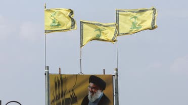 Hezbollah flags flutter atop a poster depicting Lebanon's Hezbollah leader Sayyed Hassan Nasrallah, in Kfarchouba, near the border with Israel, southern Lebanon October 8, 2023. (Reuters)