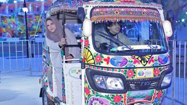 Visitors pose for picture in a rickshaw decorated with truck art during the Pakistan Cultural Week at Riyadh Season in Riyadh, Saudi Arabia, on December 01, 2023. (Nosheen Wasim)
