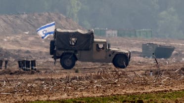 An Israeli flag flies on a military vehicle as the Israeli army operates at the border with Gaza, amid the ongoing conflict between Israel and the Palestinian group Hamas, as seen from southern Israel, December 5, 2023. (Reuters)