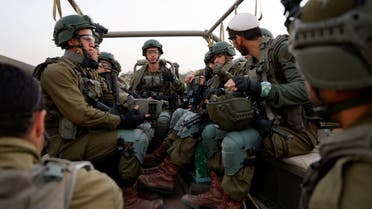 Israeli soldiers sit in a military vehicle, amid the ongoing conflict between Israel and the Palestinian militia group Hamas, near Israel's border with Gaza, in southern Israel, December 4, 2023. (Reuters)