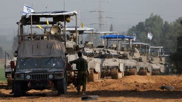 An Israeli soldier stands next to a military vehicle and a convoy of tanks near Israel's border with Gaza, amid the ongoing conflict between Israel and the Palestinian militia group Hamas, in Israel, December 4, 2023. (Reuters)