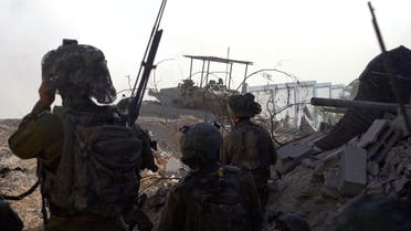 Israeli soldiers take position during the ongoing ground operation of the Israeli army against Palestinian group Hamas, in a location given as Jabalya, in Gaza, in this handout still image obtained from a video released on December 2, 2023. (Reuters)