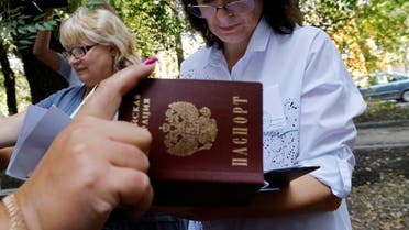 A member of an electoral commission checks a passport of a voter at a mobile polling station during local elections held by the Russian-installed authorities in the course of Russia-Ukraine conflict in Donetsk, Russian-controlled Ukraine, September 2, 2023. (Reuters)