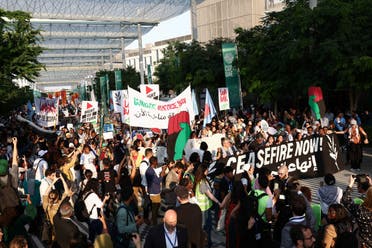 People hold banners and placards during a protest for climate justice and a cease fire in Gaza, amid the ongoing conflict between Israel and the Palestinian militant group Hamas, during the United Nations Climate Change Conference COP28, in Dubai, United Arab Emirates, December 9, 2023. (Reuters)