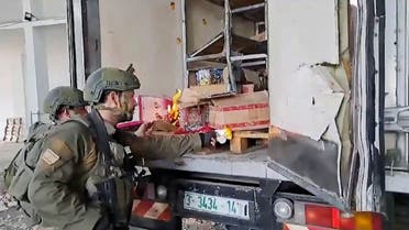 This image from a video shows Israel Army troops trying to burn food and water supplies in the back of an abandoned truck in Gaza. (AP)