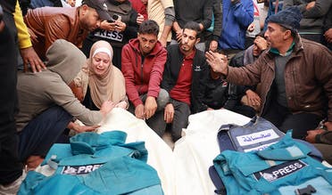 Relatives and colleagues of two Palestinian journalists Hasouna Slim and Sari Mansoor, killed in an Israeli strike, mourn over their bodies during their funeral in Deir al-Balah in the southern Gaza Strip on November 19, 2023. (AFP/File)
