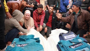 Relatives and colleagues of two Palestinian journalists Hasouna Slim and Sari Mansoor, killed in an Israeli strike, mourn over their bodies during their funeral in Deir al-Balah in the southern Gaza Strip on November 19, 2023. (AFP/File)