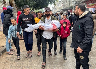 A mourner carries the body of a Palestinian child killed in Israeli strikes on houses, amid the ongoing conflict between Israel and Hamas, in Rafah, in the southern Gaza Strip on December 13, 2023. (Reuters)