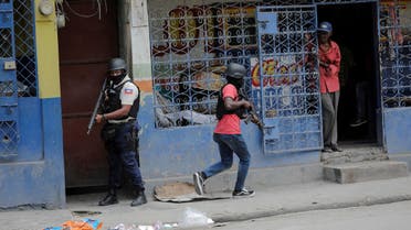 Un hombre mira desde una tienda mientras la policía patrulla las calles después de que miembros de una pandilla intentaran atacar una comisaría, en Puerto Príncipe, Haití, el 25 de abril de 2023. (Reuters)