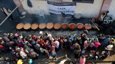 Palestinians gather to receive food cooked by a charity kitchen, amid the ongoing conflict between Israel and Hamas, in Rafah in the southern Gaza Strip, December 17, 2023. (Reuters)