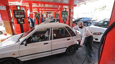 A man fills his car with petrol at a gas station in the Iranian capital Tehran, October 27, 2021. Iranian authorities blamed a mysterious cyberattack for unprecedented disruption to the country's fuel distribution network. (Photo by ATTA KENARE / AFP)