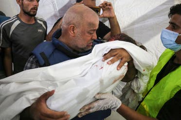 Al-Jazeera correspondent Wael Al-Dahdouh mourns over the body of one of his three children who were killed along with his wife in an Israeli strike in the Nuseirat camp, at Al-Aqsa hospital in Deir Al-Balah on the southern Gaza Strip, on October 25, 2023. (File photo: AFP)